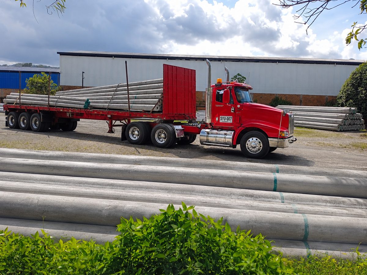 Tractomula cargada con postes de concreto centrifugado lista para despacho nacional — PRECOLL S.A.S.